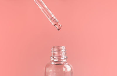 Close-up of bottle against pink background