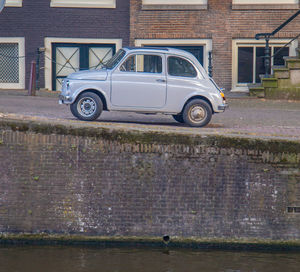 Vintage car parked against building in city