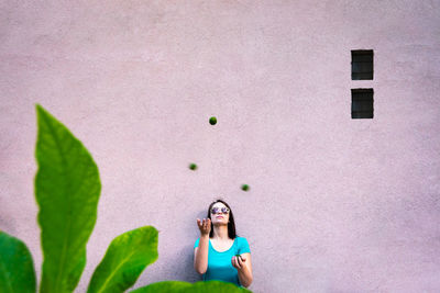 Woman looking up against pink wall