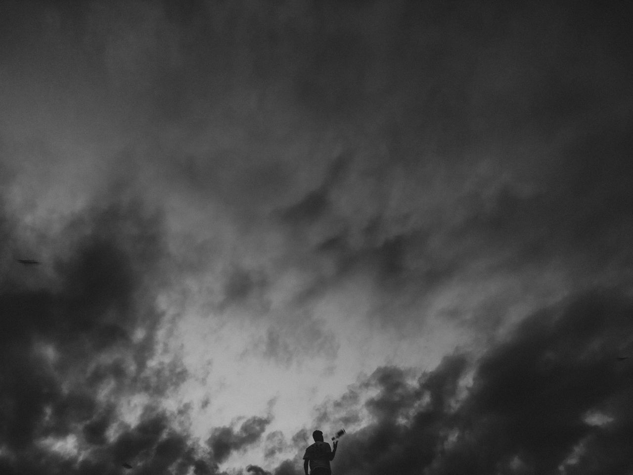 sky, cloud, darkness, black and white, monochrome, silhouette, monochrome photography, nature, storm, low angle view, beauty in nature, outdoors, overcast, thunder, dramatic sky, environment, storm cloud, cloudscape, dark, scenics - nature