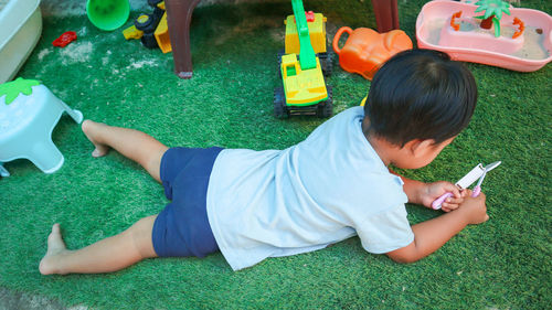 High angle view of boy lying on grass