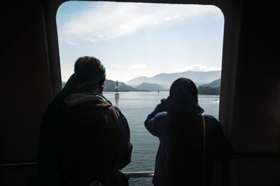 Rear view of people looking at sea against sky