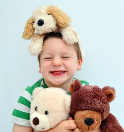 Portrait of cute boy with toy against white background