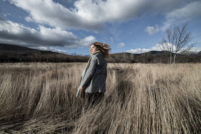 Woman standing on field against sky