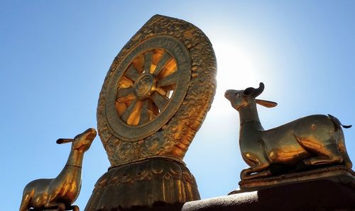 Low angle view of angel statue against clear blue sky