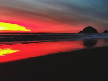 Scenic view of sea against dramatic sky during sunset