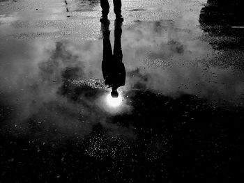 Low section of man with reflection in puddle