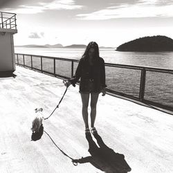 Full length of woman with dog on ship against sky