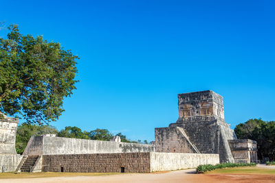 Old temple against clear blue sky during sunny day