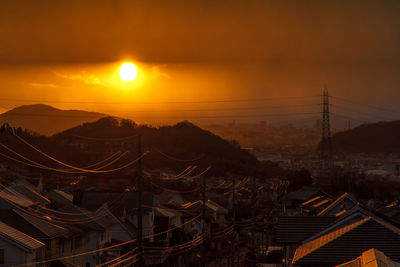 Aerial view of illuminated mountains against sky during sunset