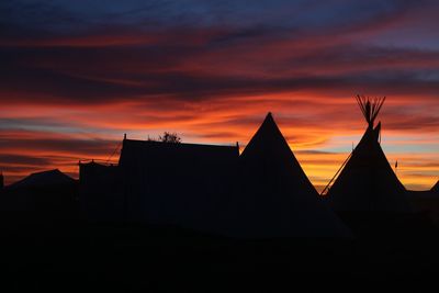 Low angle view of silhouette buildings against dramatic sky