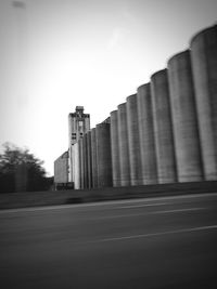 Road by buildings against sky