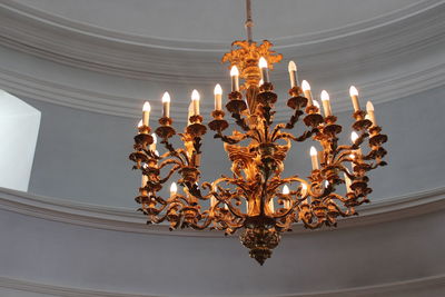 Low angle view of illuminated chandelier hanging from ceiling