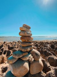 Stack of pebbles on beach against clear sky