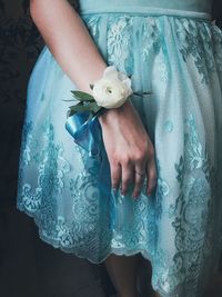 Low section of woman holding blue flower