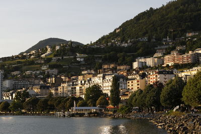 Townscape by river against sky in town