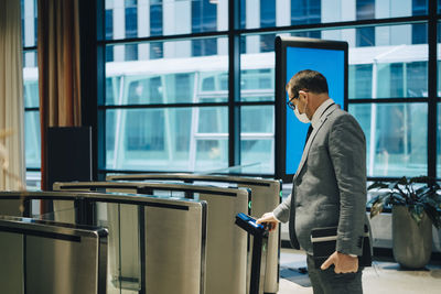 Businessman scanning smart phone to enter subway station during covid-19