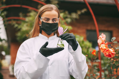 Full length of woman standing by flowering plants