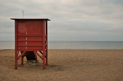 Lifeguard hut on beach against sky