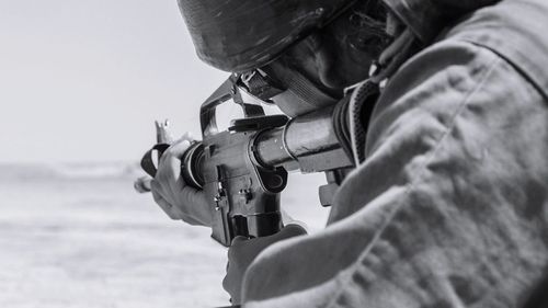 Cropped image of man using rifle