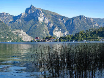 Scenic view of lake by mountains against sky