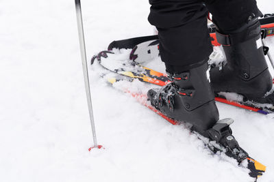 Low section of person skiing on snow field