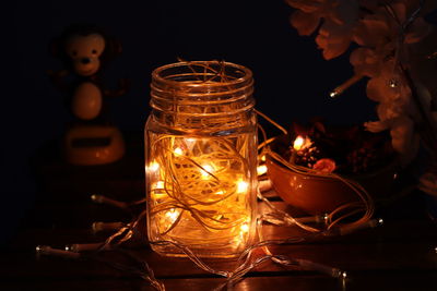 Close-up of lit candle in glass