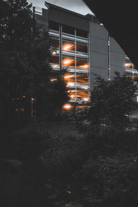 Illuminated street light by building at night