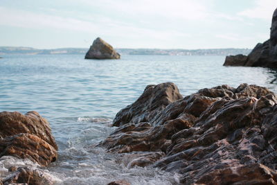 Rock formation in sea against sky