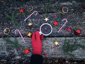 High angle view of hand holding cigarette on table