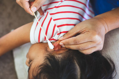 Nurse cleaning wound on girl ear