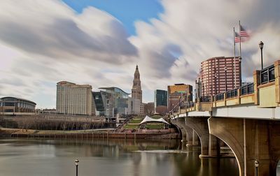 Bridge over river in city against sky