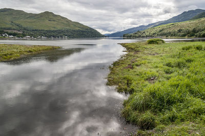 Scenic view of river amidst mountains against sky