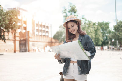 Young woman standing on street in city