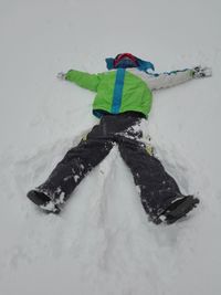 Woman lying on snow covered land