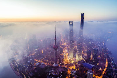 High angle view of city lit up at sunset