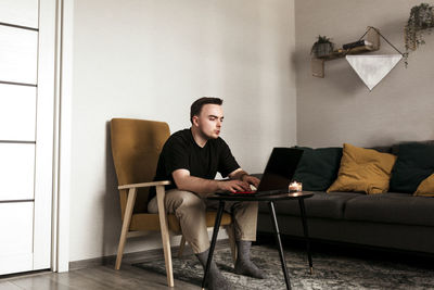 Portrait of young woman sitting on sofa at home