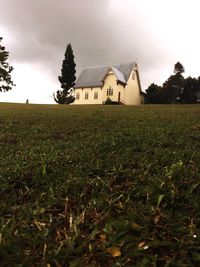 Houses on grassy field against sky