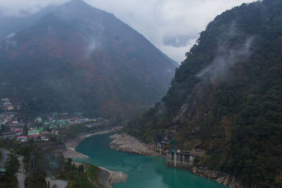 Scenic view of river amidst mountains against sky