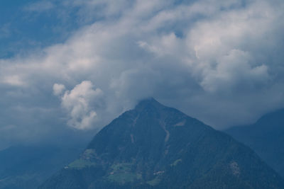 Scenic view of mountain range against cloudy sky