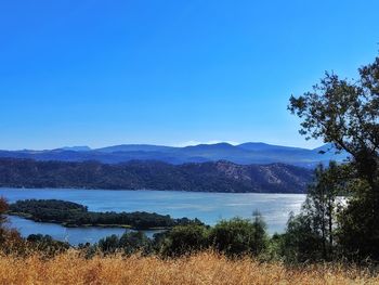 Scenic view of lake against clear blue sky