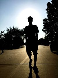 Rear view of silhouette man standing against sky