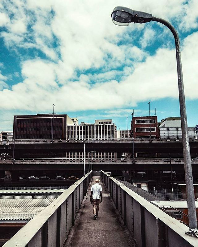 sky, railing, built structure, architecture, full length, cloud - sky, rear view, lifestyles, walking, leisure activity, men, building exterior, cloud, the way forward, person, cloudy, standing