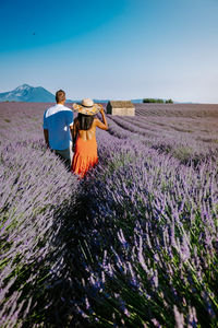 Rear view of couple on field against sky