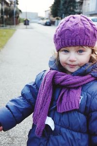 Portrait of girl standing in warm clothing on road