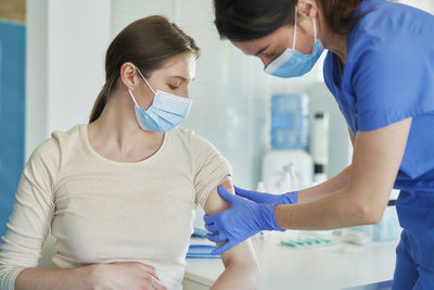 Doctor applying bandage to female patient in hospital