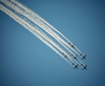 Low angle view of airplane flying against clear blue sky