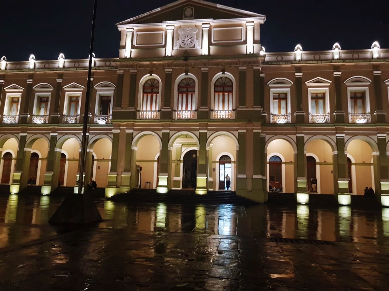 REFLECTION OF ILLUMINATED BUILDING IN WATER AT NIGHT