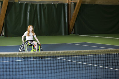 Girl in wheelchair playing tennis