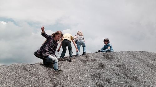 Low angle view of people against cloudy sky